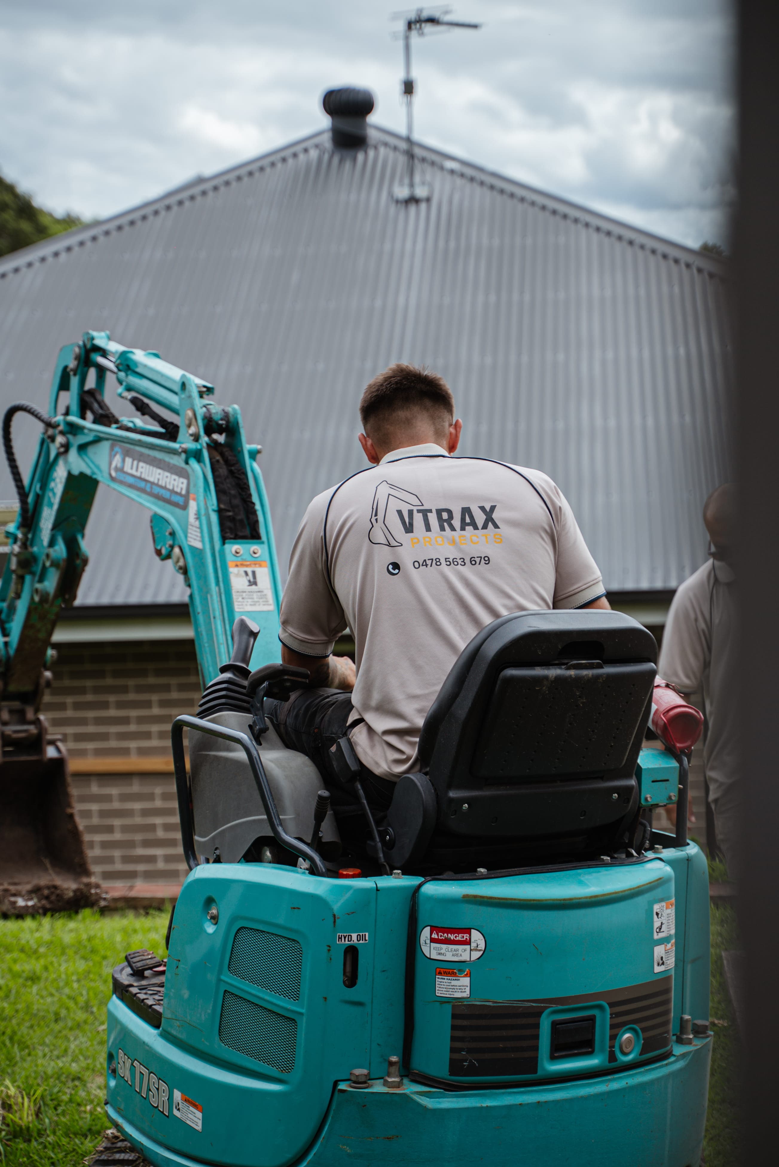 Excavator preparing ground for retaining wall